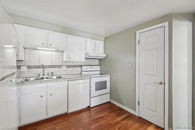 a kitchen with a sink cabinets and wooden floor