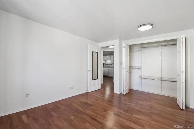 a view of a kitchen with a refrigerator and wooden floor