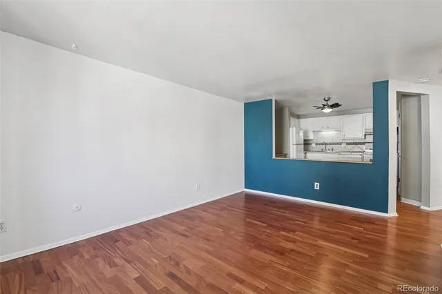 a view of a big room with wooden floor and windows