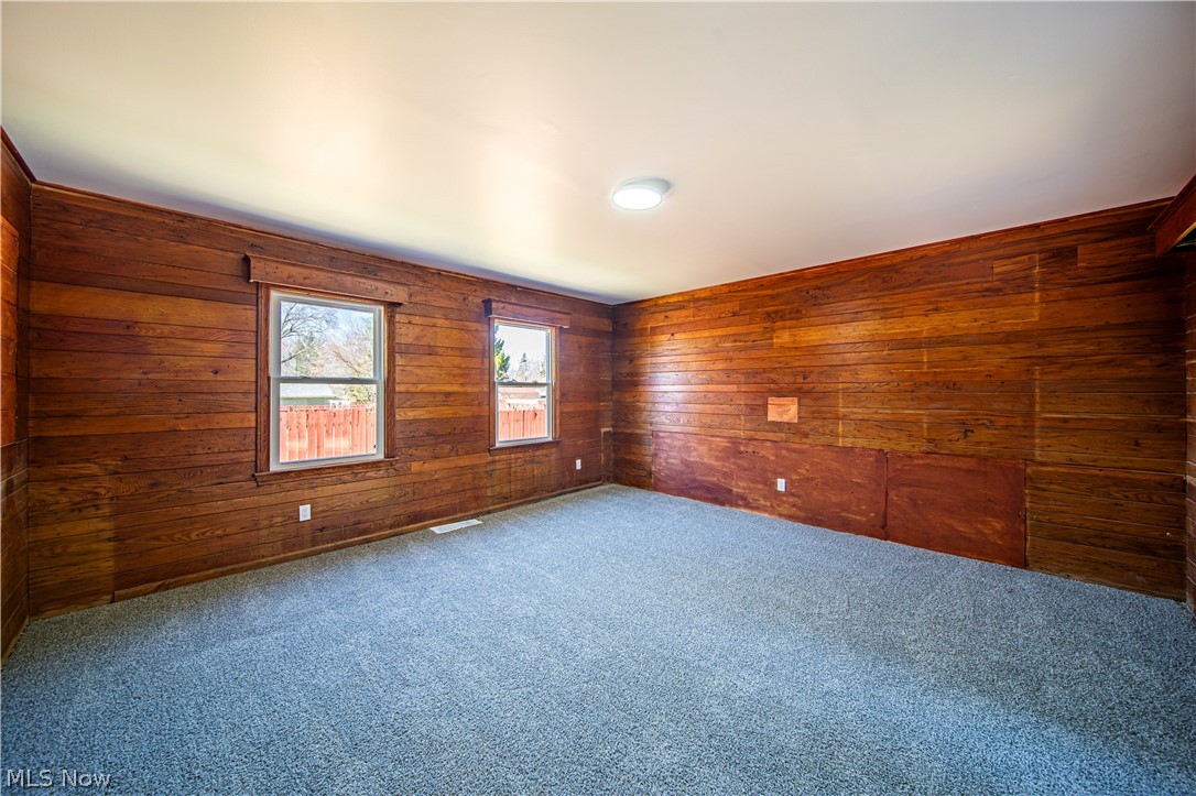 9412 Oakdale Road Parma, OH 44129 - Photo 12 of 38 Empty room with wood walls and dark carpet