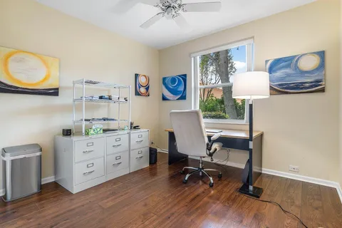 a view of a workspace with furniture and a window