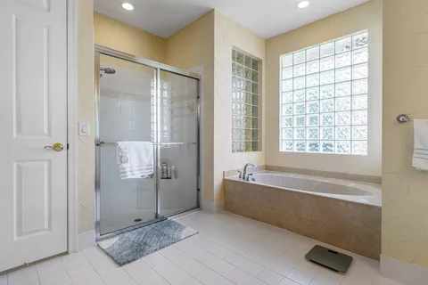 a spacious bathroom with a tub shower and windows