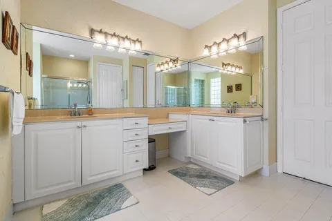 a spacious bathroom with a double vanity sink and a mirror