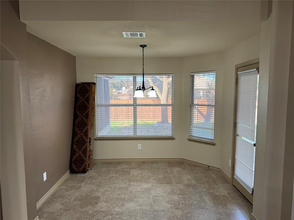 3624 Big Horn Trail Denton, TX 76210 - Photo 3 of 10 an empty room with chandelier and windows