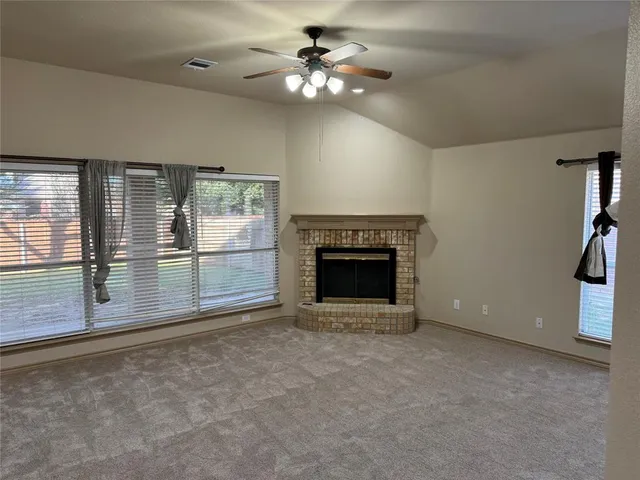 an empty room with fireplace and fan