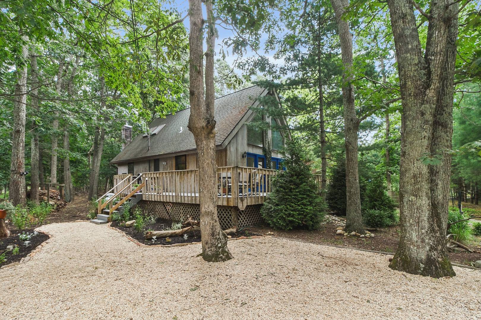 62 Broadway East Hampton, NY 11937 - Photo 17 of 20 a view of a house with large trees and wooden fence