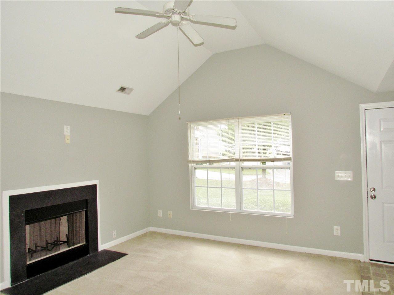 905 Roxy Street Raleigh, NC 27610 - Photo 5 of 30 a view of an empty room with a fireplace and a window