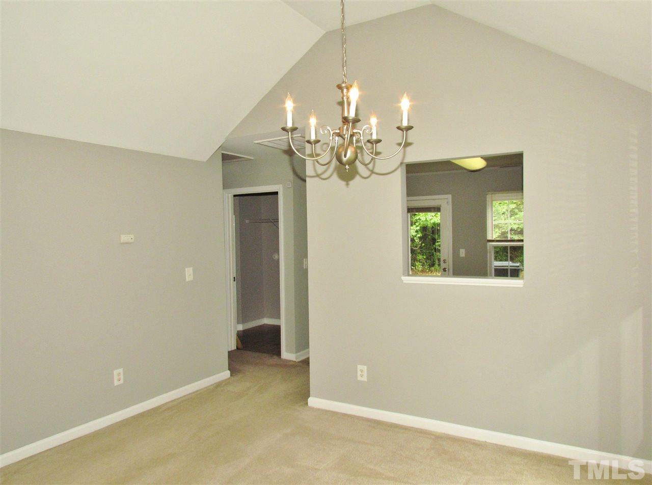 905 Roxy Street Raleigh, NC 27610 - Photo 7 of 30 an empty room with a chandelier fan and wooden floor