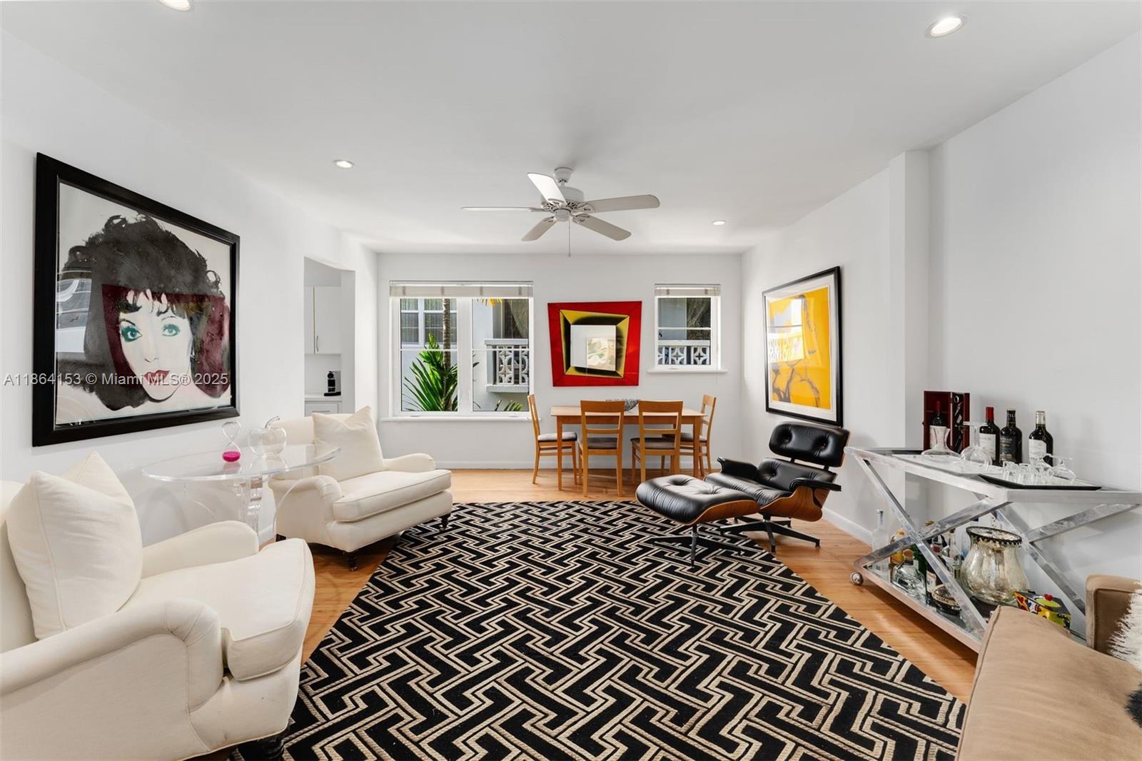 a living room with furniture two window and a table