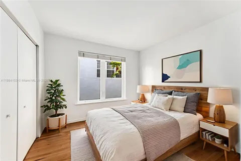 a bedroom with a large bed and a potted plant