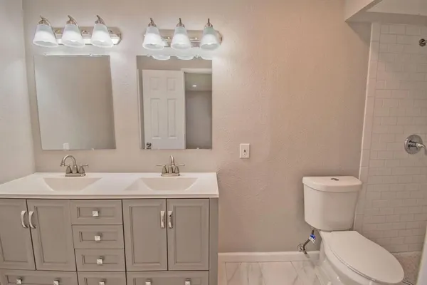 a bathroom with a toilet sink and mirror