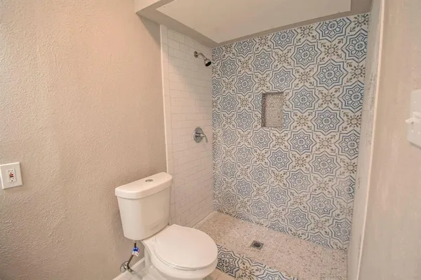 a white toilet sitting next to a shower