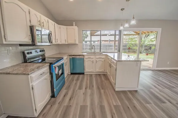 a kitchen with a sink stove and cabinets
