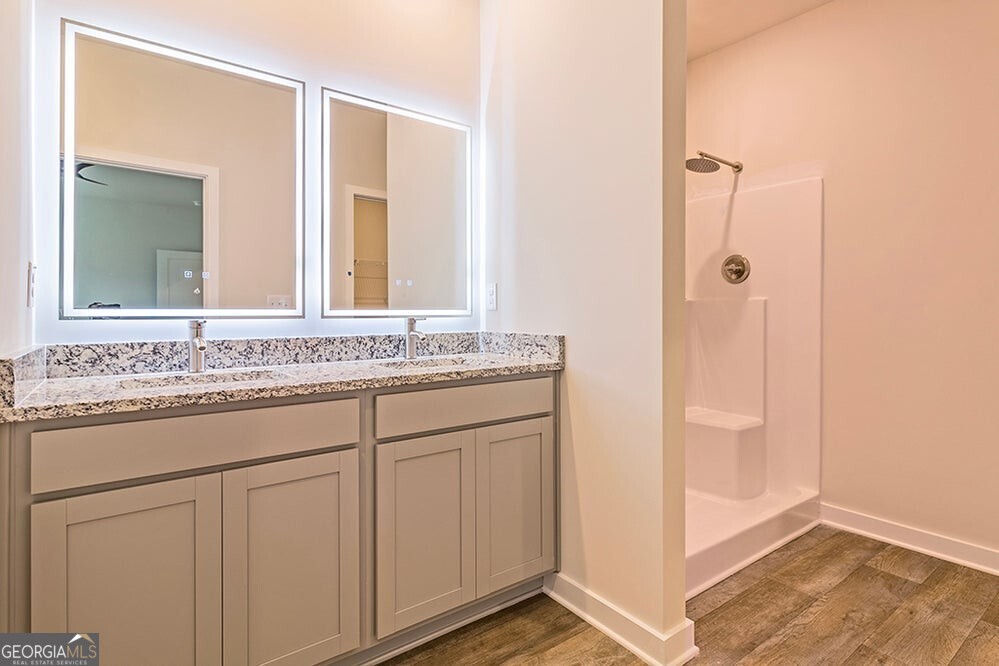 148 Post Oak Drive, Unit 139 Jackson, GA 30233 - Photo 20 of 24 a bathroom with a granite countertop sink and a mirror