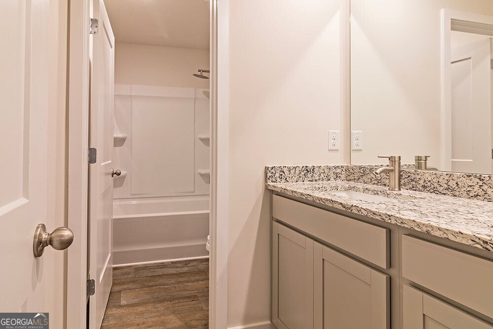 148 Post Oak Drive, Unit 139 Jackson, GA 30233 - Photo 22 of 24 a bathroom with a granite countertop sink and a mirror