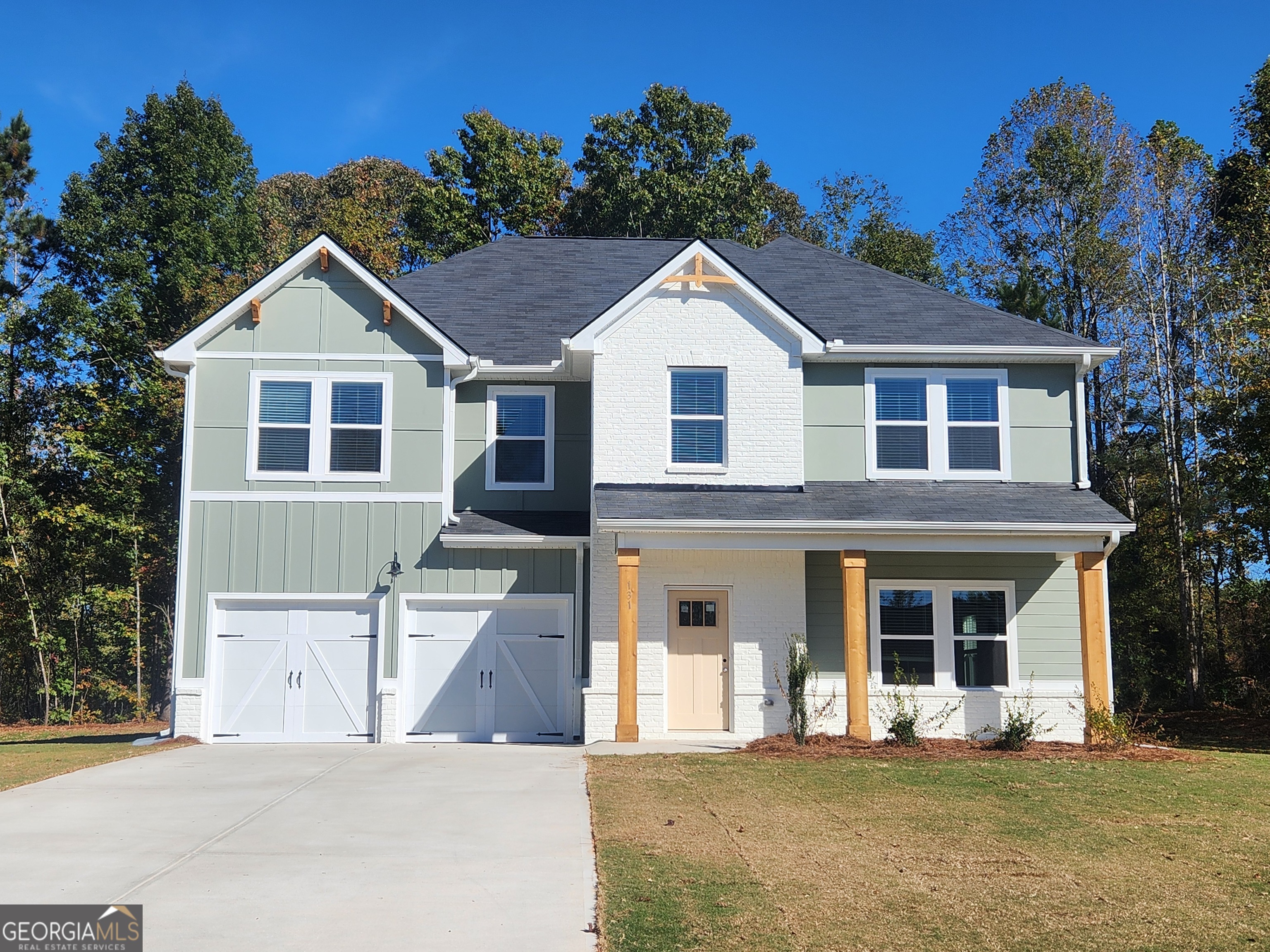 148 Post Oak Drive, Unit 139 Jackson, GA 30233 - Photo 3 of 24 a front view of a house with yard and trees in the background