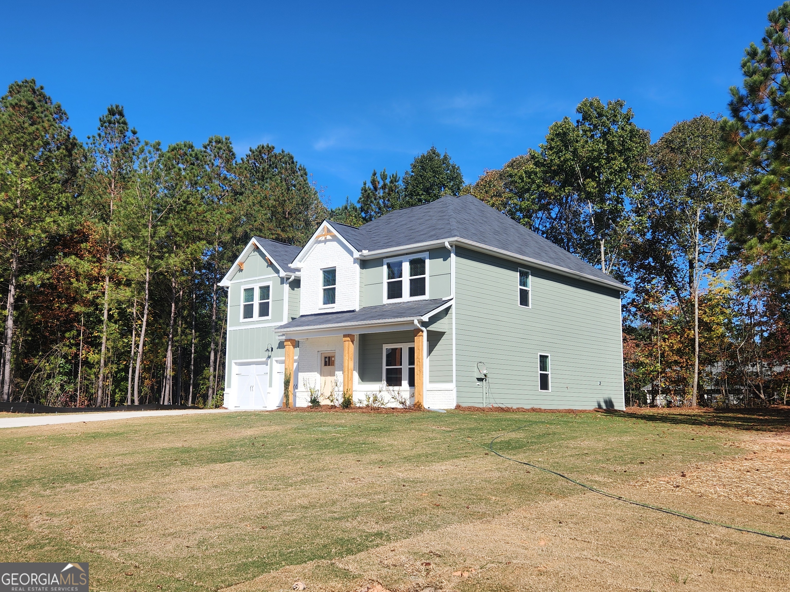 148 Post Oak Drive, Unit 139 Jackson, GA 30233 - Photo 5 of 24 a view of a white house with a big yard and large tree