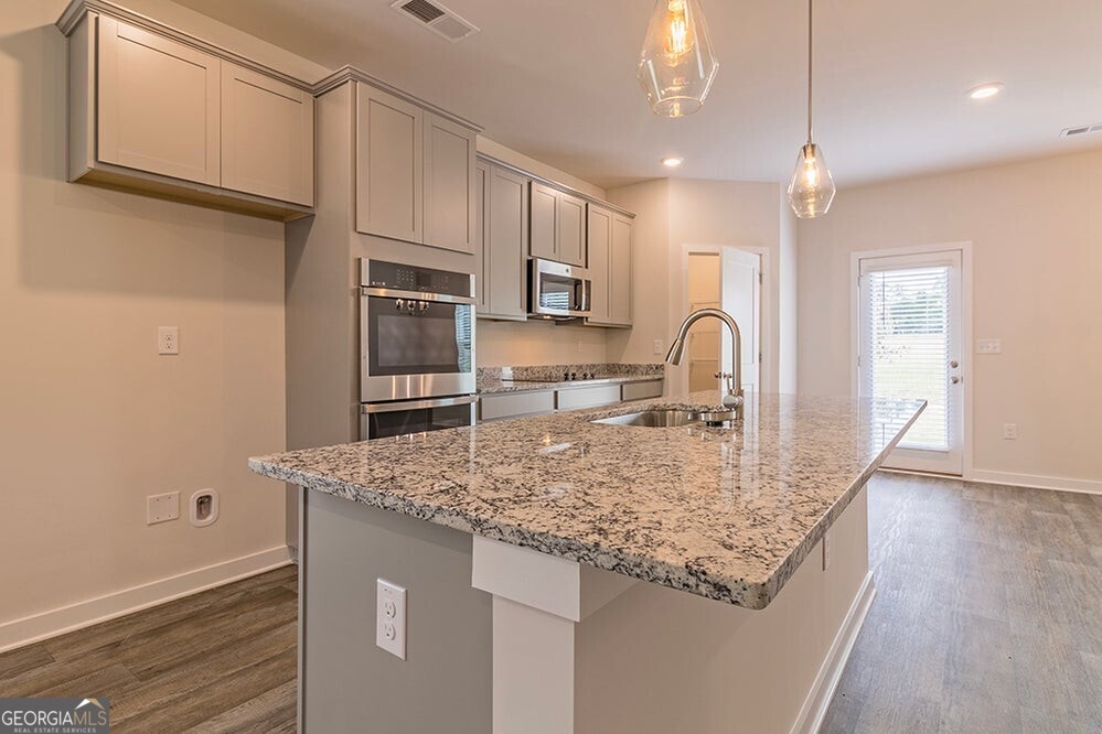 148 Post Oak Drive, Unit 139 Jackson, GA 30233 - Photo 9 of 24 a kitchen with stainless steel appliances granite countertop a sink refrigerator and cabinets