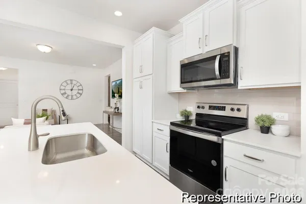 a kitchen with stainless steel appliances granite countertop a sink a stove a microwave and cabinets