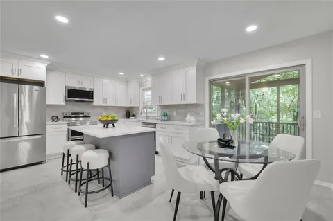 a kitchen with a refrigerator and a dining table