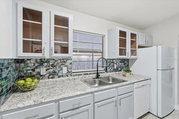a kitchen with stainless steel appliances granite countertop a sink and a white cabinets