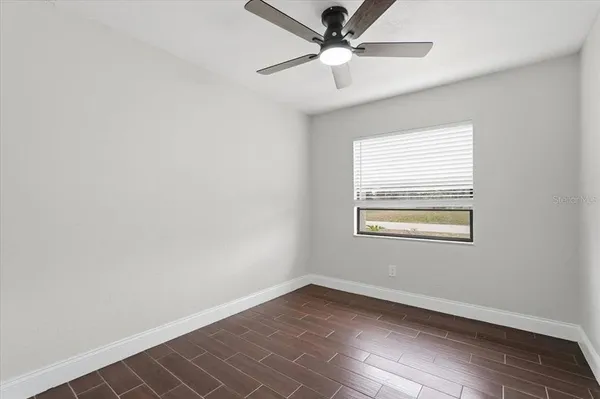 an empty room with a window and a fan