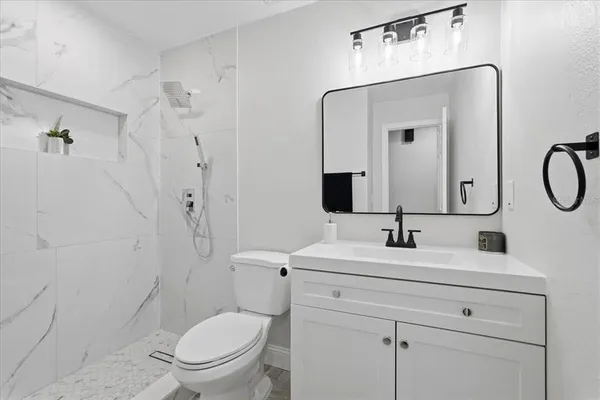 a bathroom with a toilet sink shower and mirror