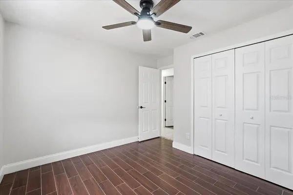 a view of an empty room with wooden floor