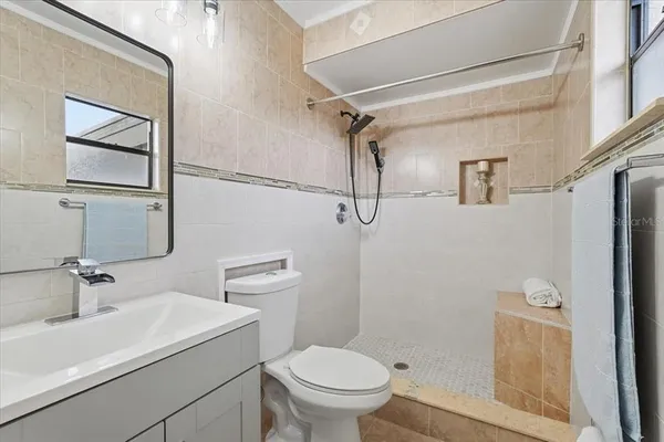 a bathroom with a sink a toilet and shower