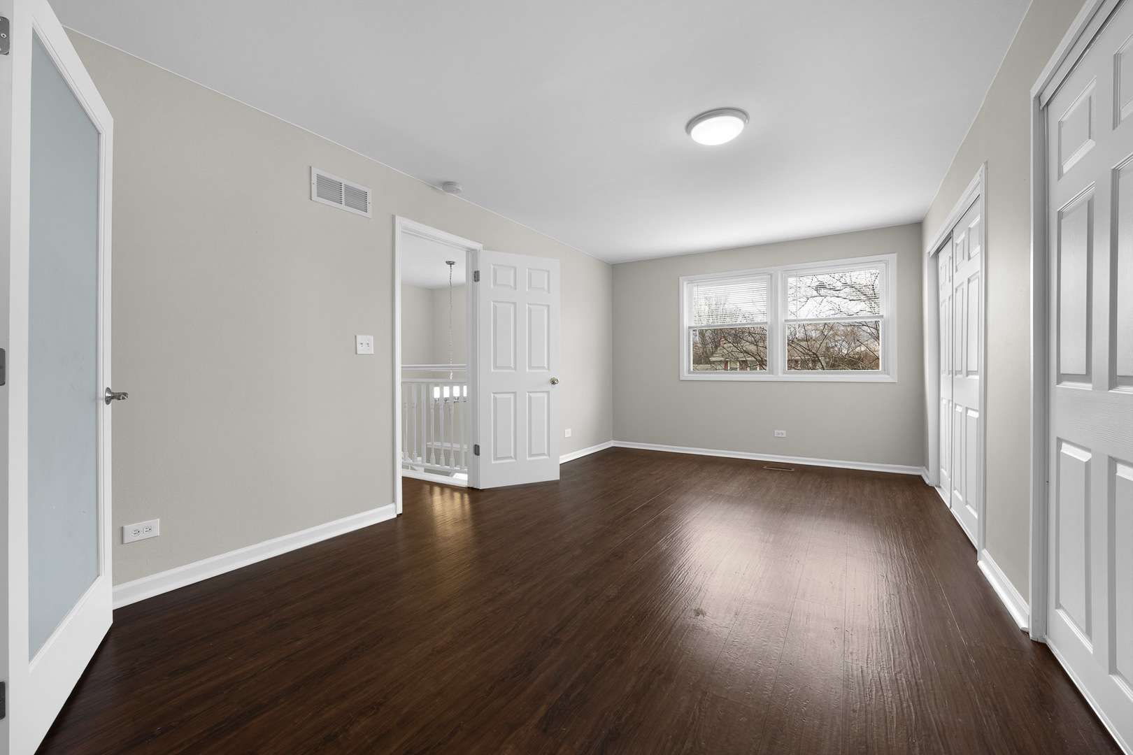 3497 Ronald Road Crete, IL 60417 - Photo 7 of 17 an empty room with wooden floor and windows