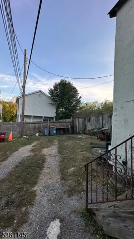 a backyard of a house with table and chairs a barbeque