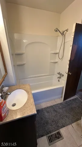 a bathroom with a granite countertop sink mirror vanity and toilet