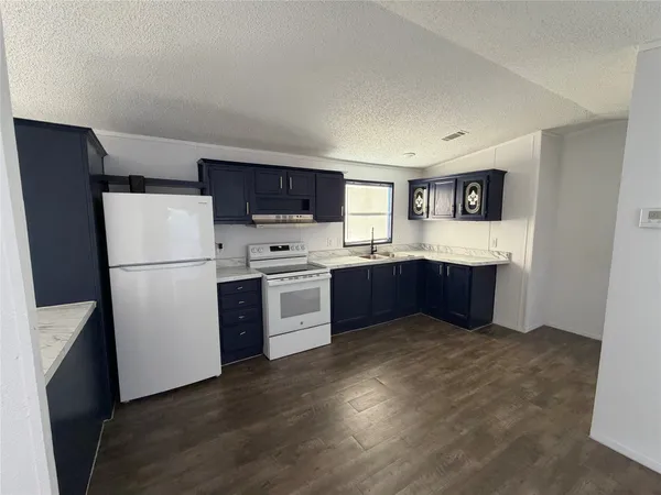 a kitchen with stainless steel appliances granite countertop a refrigerator a stove a sink dishwasher and a refrigerator