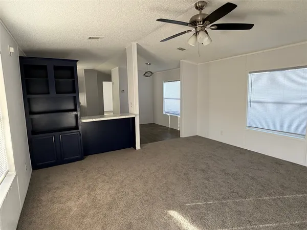 a view of empty room with window and cabinet