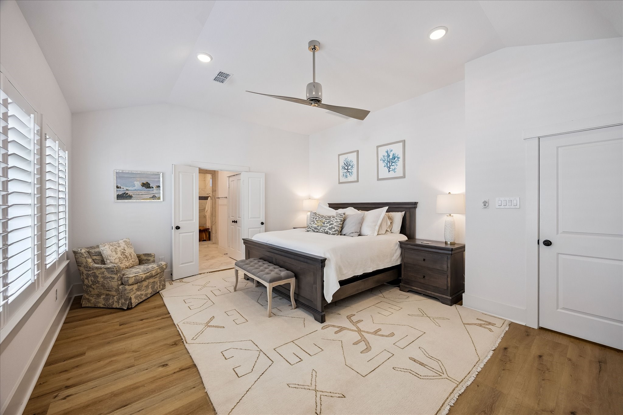 2512 Swang Pl. Houston, TX 77008 - Photo 21 of 46 This spacious bedroom features vinyl plank flooring, recessed lighting, large windows with wood shutters, modern ceiling fan, and easy access to an adjoining bathroom through double doors.