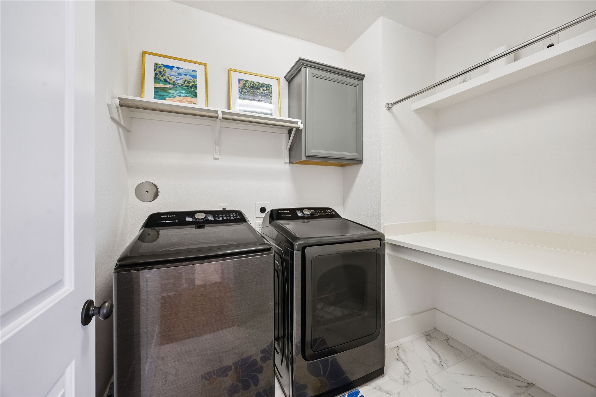 2512 Swang Pl. Houston, TX 77008 - Photo 30 of 46 This laundry room features modern appliances which stay, sleek gray cabinet, a hanging rod, and folding area, offering both functionality and style.