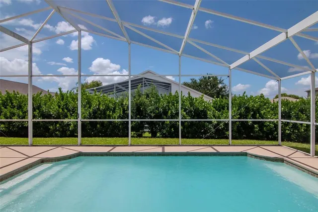 a view of a swimming pool with a yard and sitting area