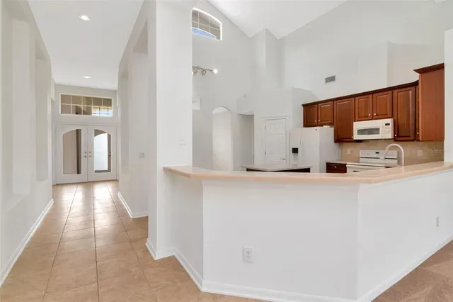 a view of a refrigerator a sink a microwave and cabinets