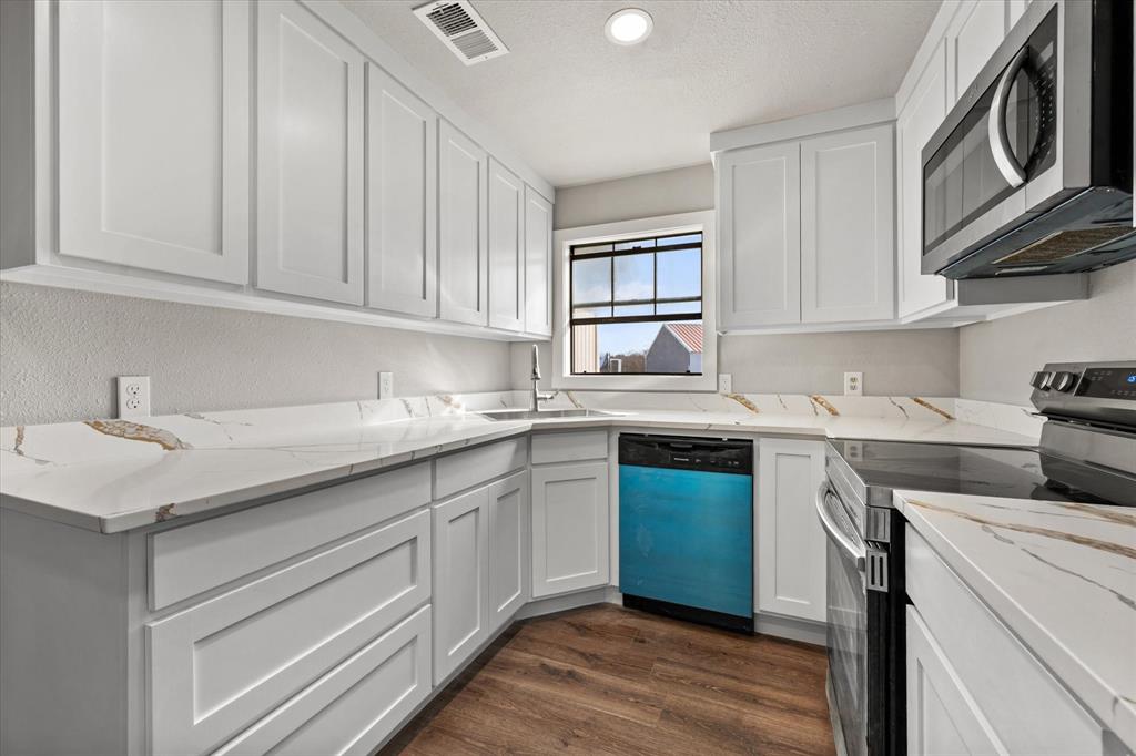 443 County Road 3799 Springtown, TX 76082 - Photo 11 of 33 Kitchen featuring stainless steel appliances, white cabinets, dark wood-style floors, light stone counters, and recessed lighting