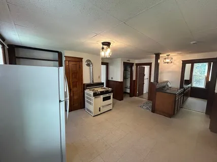 a view of kitchen with cabinets and window