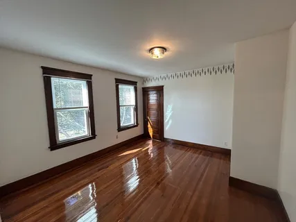 wooden floor in an empty room with a window