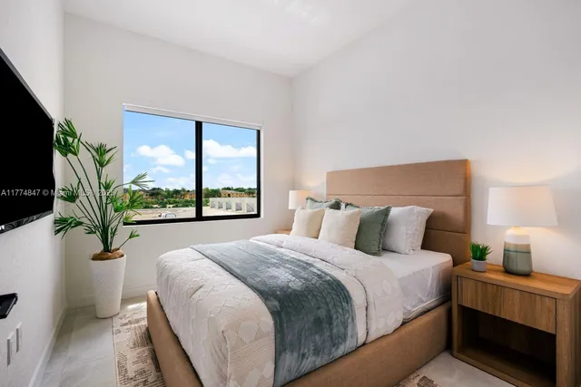 a large bed sitting in a bedroom next to a window