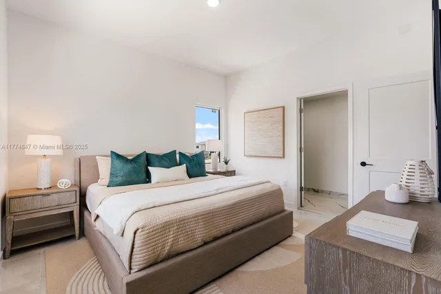 a bedroom with a bed and a lamp with the dresser