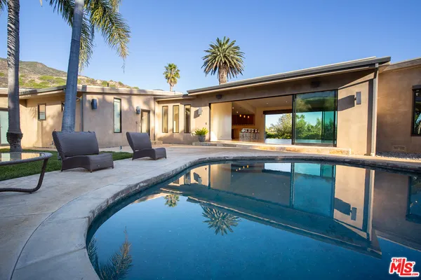 a swimming pool with outdoor seating