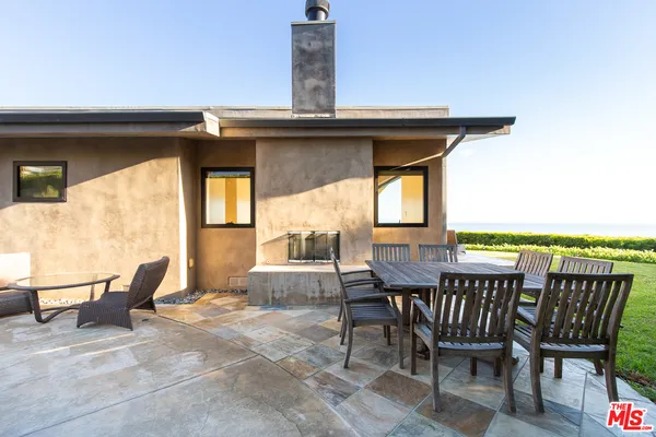 a view of a patio with table and chairs and wooden floor