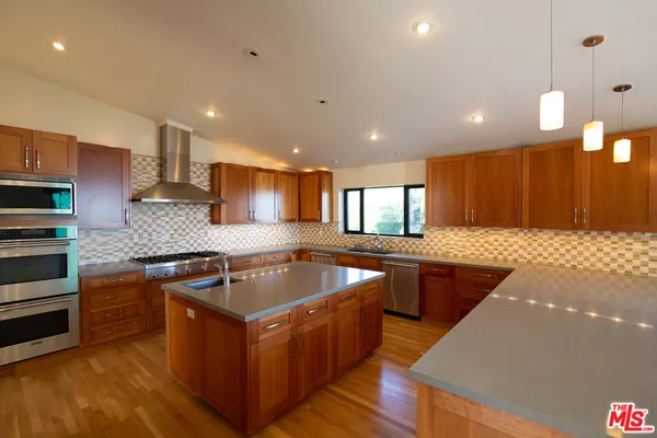 a kitchen with stainless steel appliances granite countertop a stove a sink a refrigerator and a microwave