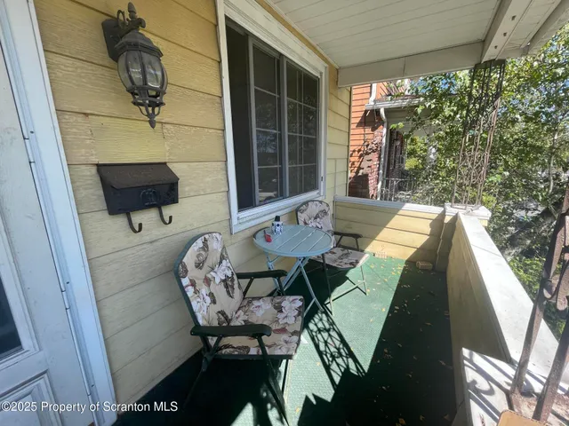 a balcony view with a table and chairs