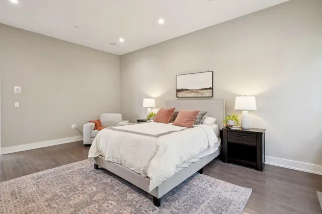 a bedroom with a large bed and a potted plant