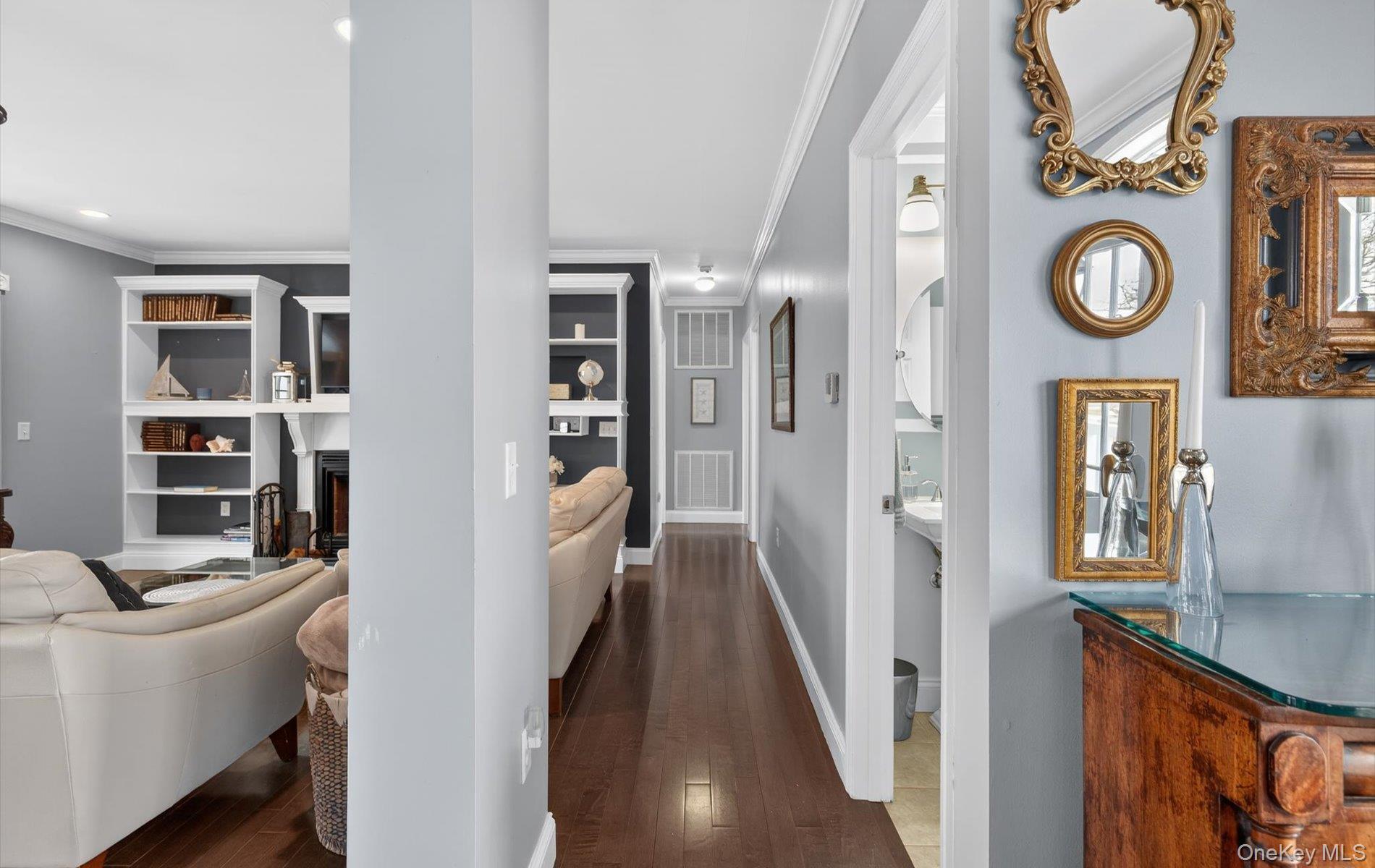 108 Awixa Avenue Bay Shore, NY 11706 - Photo 12 of 47 Hallway featuring dark wood finished floors, crown molding, and built in features