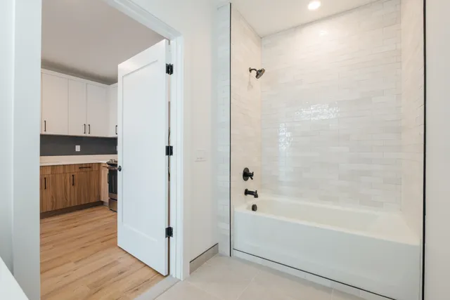 a bathroom with a bathtub a shower a sink and a window